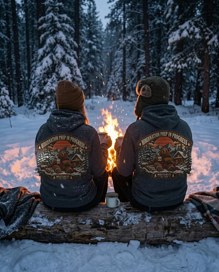 Couple in Hibernation Prep hoodies by a campfire